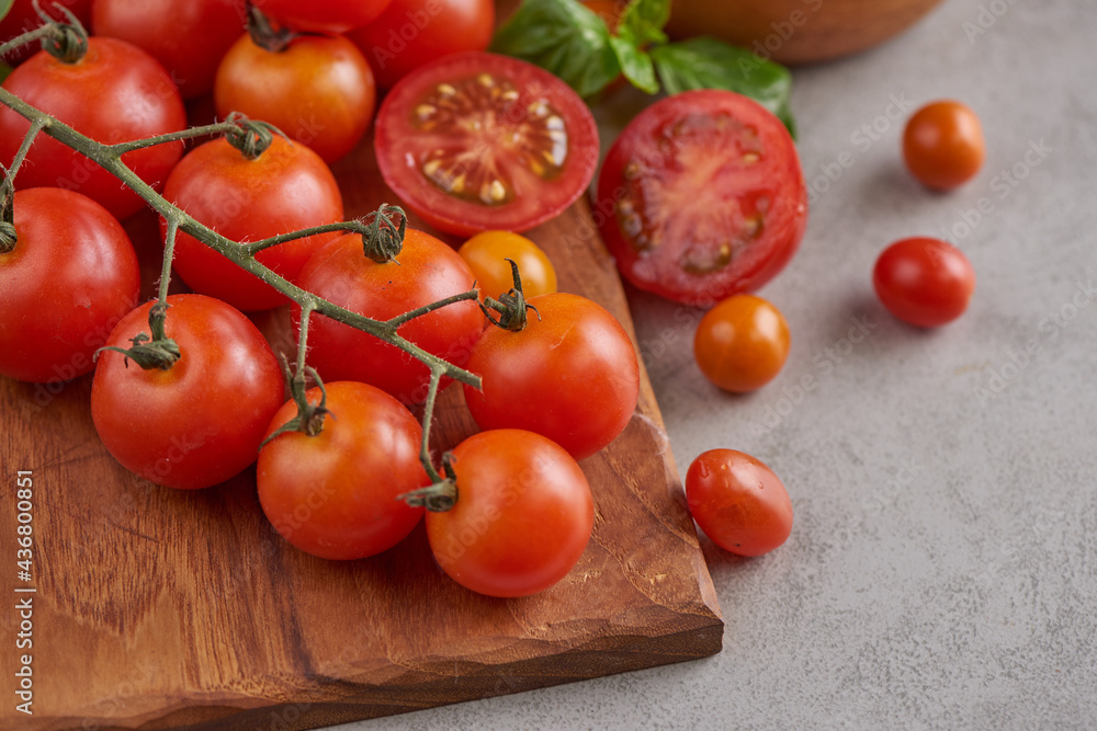 Fresh red variety of tomatoes with basil spices, pepper. Tomato vegetable concept. Vegan diet food. Harvesting tomatoes. Fresh tomato used for cooking.Top view. Fresh red variety of tomatoes with basil spices, pepper. Tomato vegetable concept. Vegan diet food. Harvesting tomatoes. Fresh tomato used for cooking.Top view.