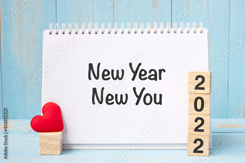 New Year New You words and 2022 cubes with red heart shape decoration on blue wooden table background. Goal, Resolution, health, Love and Happy Valentine’s day concept