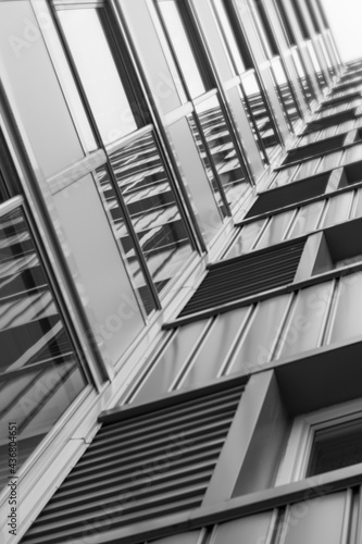 Close up of skyscraper from below. Diagonal lines. Vertical photo. B&W.