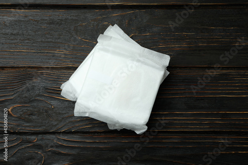 Stack of sanitary pads on wooden background