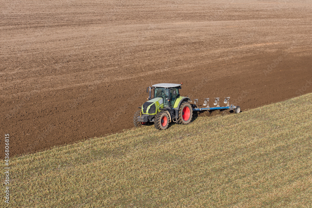 Fototapeta premium aerial view of the tractor on harvest field