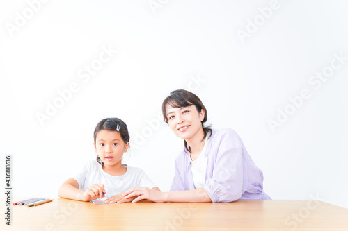 お家でお母さんとお勉強する女の子