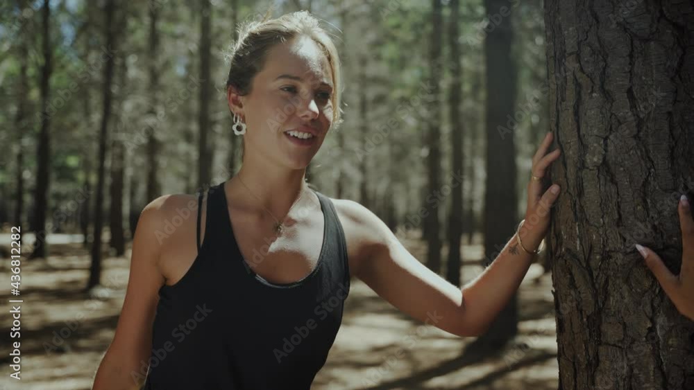 Mixed race female friends chatting and bonding together stretching in forest before going on long run Mixed race female friends chatting and bonding together stretching in forest before going on long run