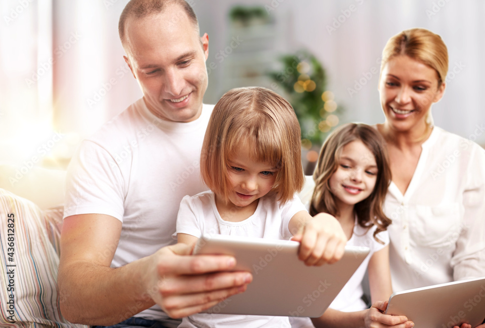 family, technology and people - happy father, mother and two daughters with tablet pc computers at home family, technology and people - happy father, mother and two daughters with tablet pc computers at home