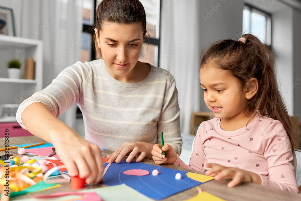 family, art and craft concept - mother spending time with her little daughter making applique of color paper at home family, art and craft concept - mother spending time with her little daughter making applique of color paper at home