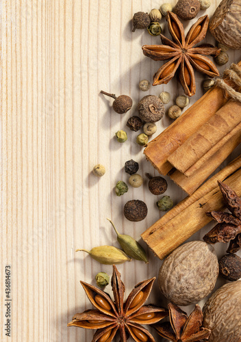Fototapeta Naklejka Na Ścianę i Meble -  Cooking spices, anise, cardamom, cinnamon rolls, nutmeg, allspice peas. Close-up top view of various spices. Spectacular wood background.