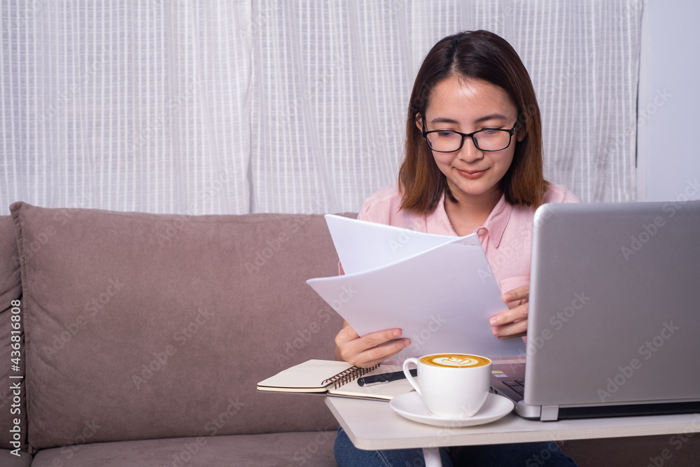 bussiness woman or student wearing glasses sitting on sofa in living room read paper sheet with computer notebook in front. Stay and Work from home and student study and learn at home office concept.
bussiness woman or student wearing glasses sitting on sofa in living room read paper sheet with computer notebook in front. Stay and Work from home and student study and learn at home office concept.
