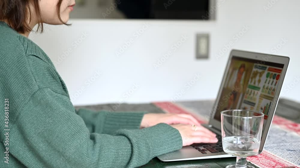 自宅で仕事をする女性と家事をする男性 自宅で仕事をする女性と家事をする男性