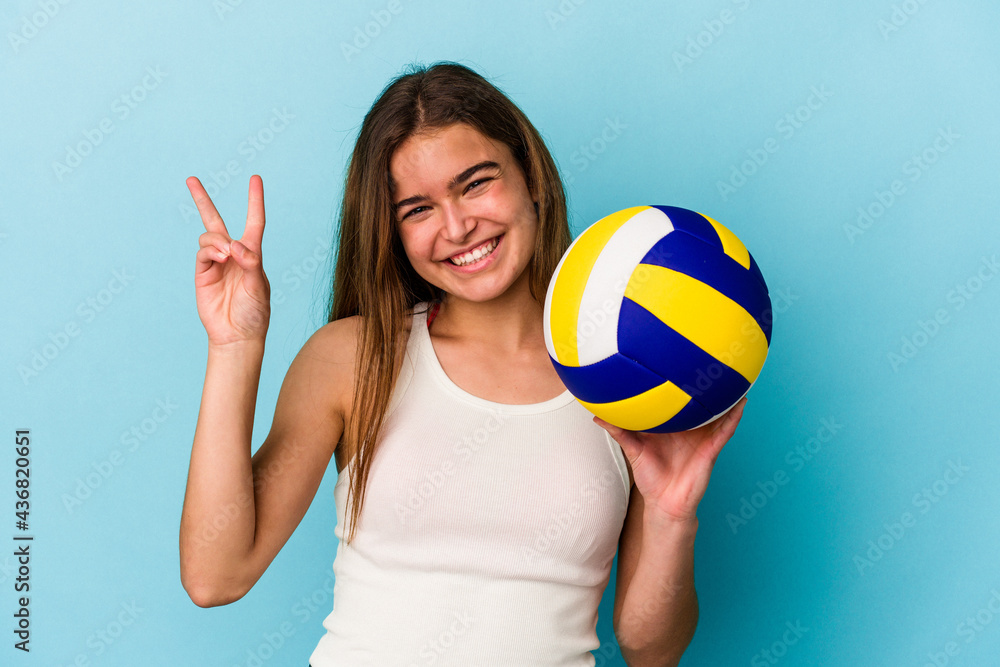 Young caucasian woman playing volleyball isolated on blue background showing number two with fingers.
