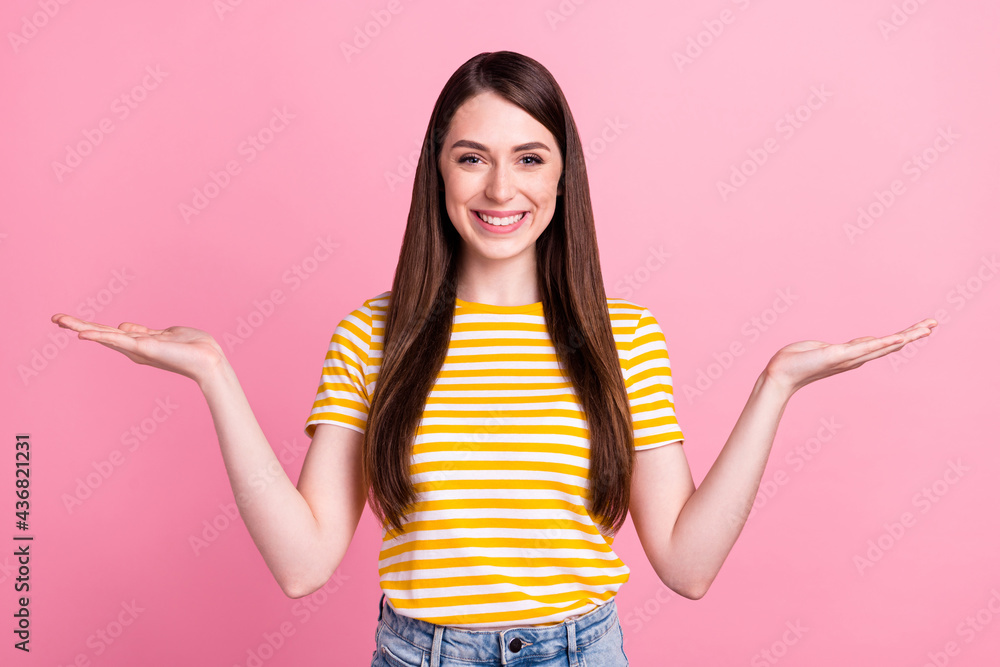 Photo of optimistic young teen lady hold empty space wear orange t-shirt isolated on pink color background Photo of optimistic young teen lady hold empty space wear orange t-shirt isolated on pink color background