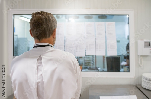 Chef looking at his work list. Scenes in motion of real teamwork by great Spanish professionals of gourmet haute cuisine for social events. 