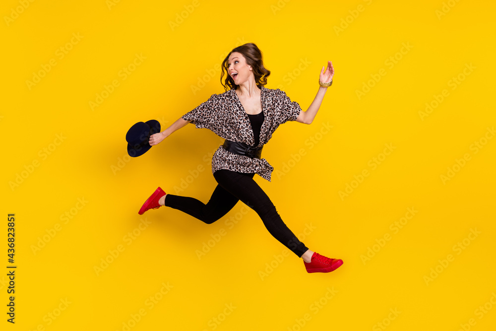 Full body profile side photo of happy nice young woman look empty space run jump sale isolated on yellow color background