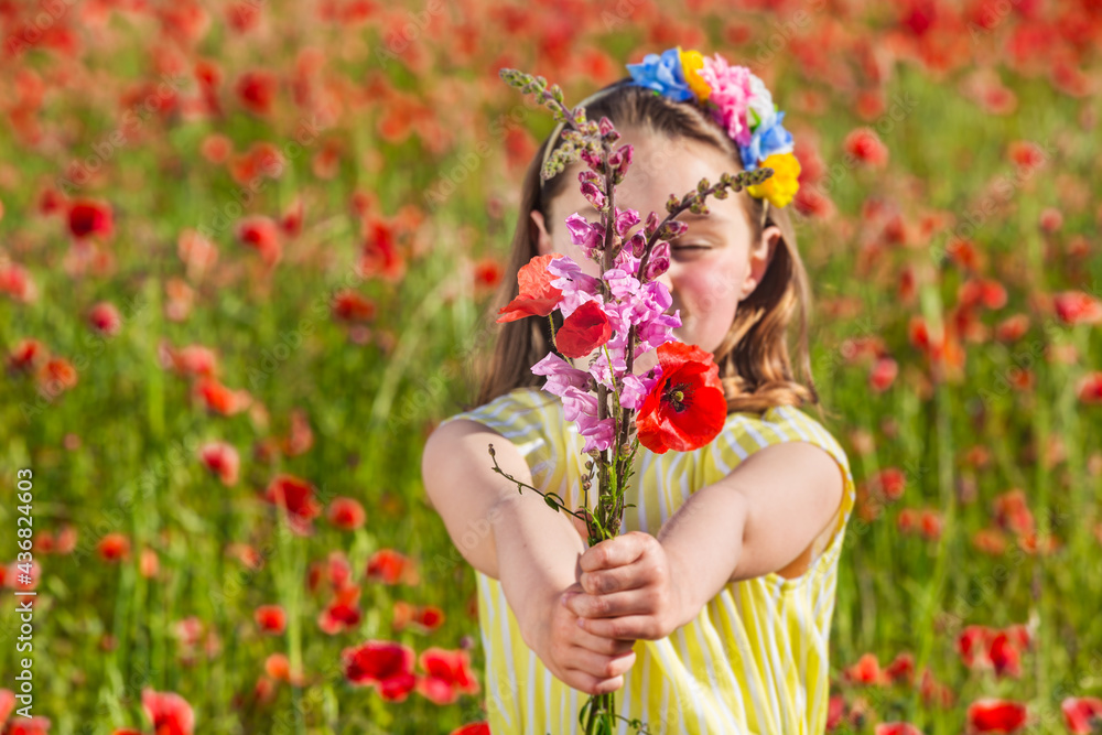 Happy girl with blooming flowers in field Happy girl with blooming flowers in field