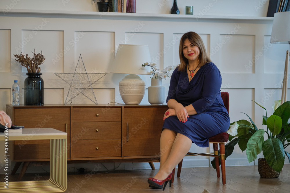 extravagant dressy lady at home. portrait of a confident mature woman. smiling woman looking at camera. Successful middle aged woman at home smiling. extravagant dressy lady at home. portrait of a confident mature woman. smiling woman looking at camera. Successful middle aged woman at home smiling.