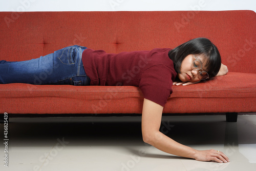 Asleep of Young beautiful Asian women dress red shirt and jeans sitting on red couch