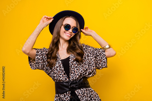 Photo of attractive happy nice young woman wear hat cool sunglass leopard blouse isolated on yellow color background