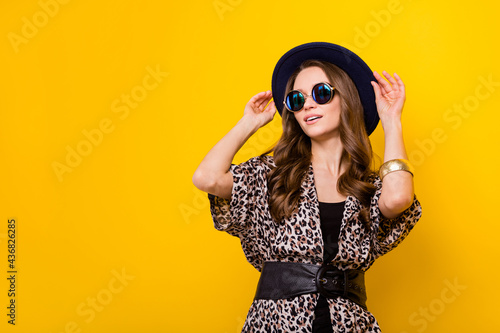Portrait of attractive dreamy chic girl dreaming touching hat copy space isolated over bright yellow color background