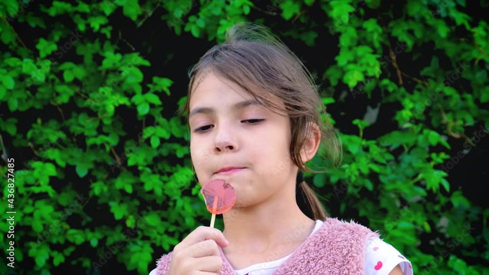 The child is eating a lollipop. Selective focus. The child is eating a lollipop. Selective focus.