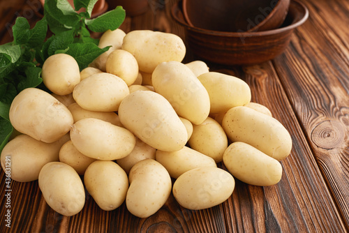 Heap of fresh raw young potatoes on a wooden table close up