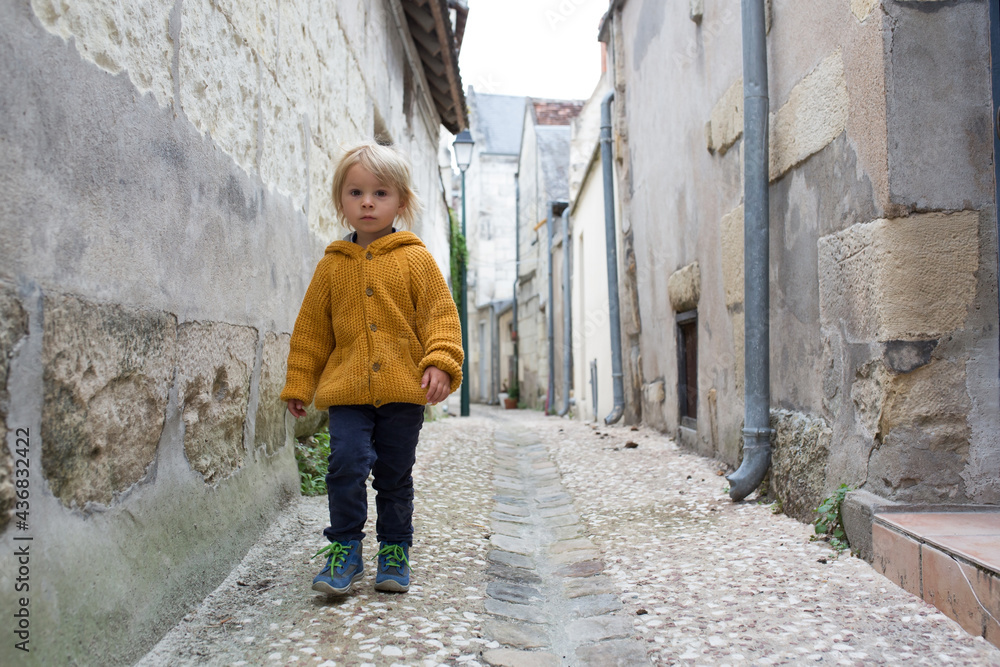 Child, boy walking in a beautiful small village street in France Child, boy walking in a beautiful small village street in France