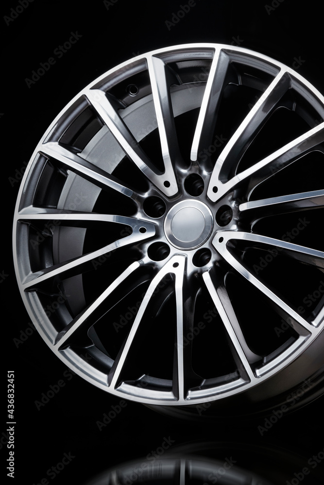 sport alloy wheel, vertical photo on a black background. slim sports spoke rim, light weight car wheel.