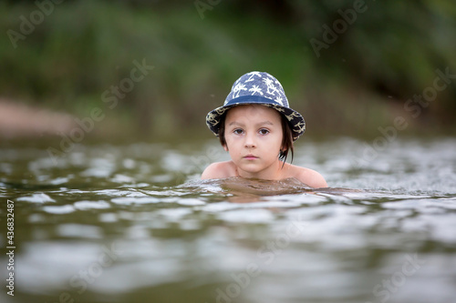 Fototapeta Naklejka Na Ścianę i Meble -  Beautiful portrait of child in lake, kid playing