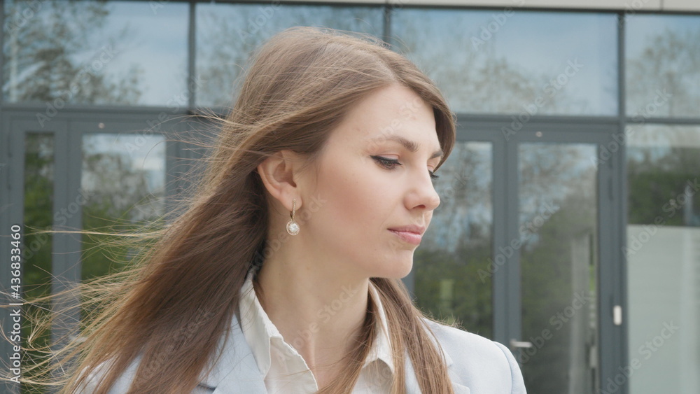 Portrait, Woman Smiling Charmingly while Standing in the Middle of Modern Urban City Landscape, Wearing Spring Coat. Happy Young Woman Enjoys Life. Business Woman portrait pretty slow motion Portrait, Woman Smiling Charmingly while Standing in the Middle of Modern Urban City Landscape, Wearing Spring Coat. Happy Young Woman Enjoys Life. Business Woman portrait pretty slow motion
