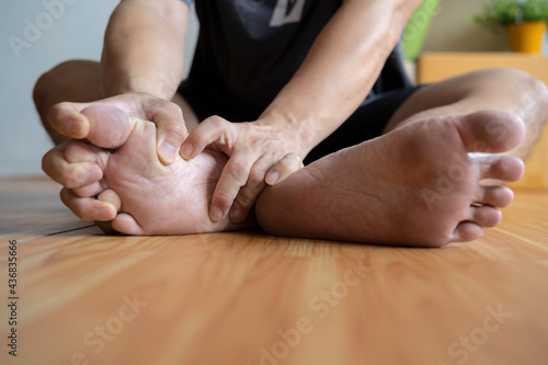 Man suffering from foot pain or numbness at home