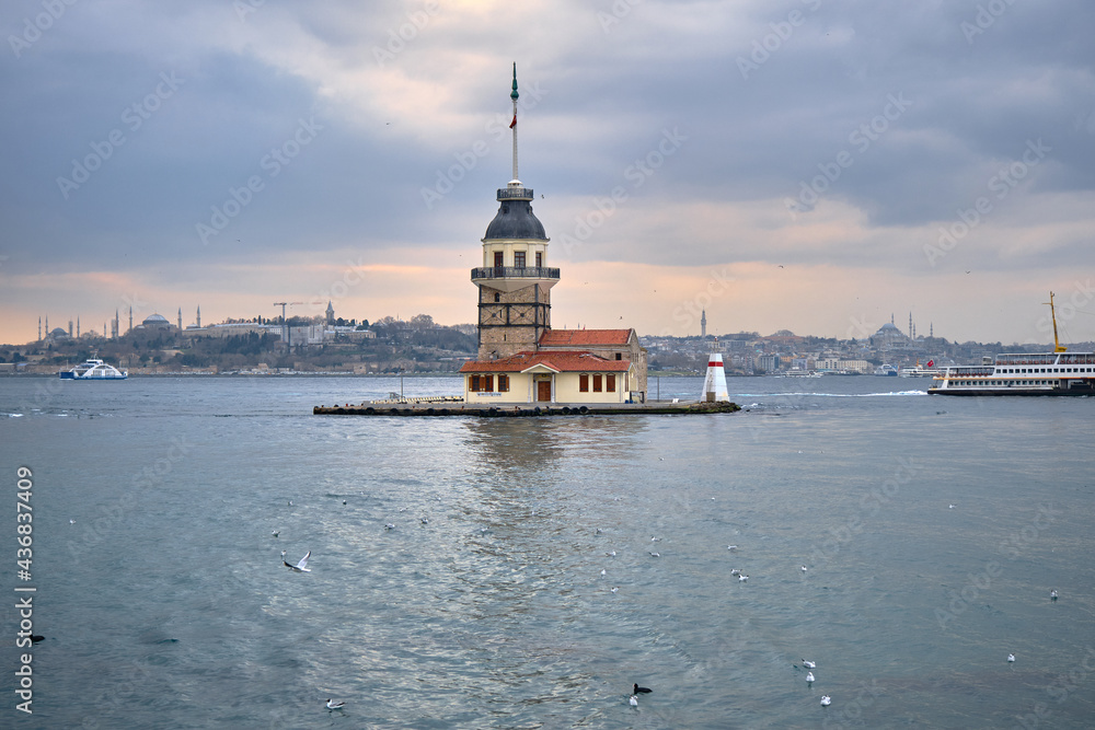 The maiden's tower (kiz kulesi) in stanbul, Turkey during overcast weather with sunshine reflection in bosporus sea. Groups of seagulls flying on sea. stanbul Turkey 01.03.2021 The maiden's tower (kiz kulesi) in stanbul, Turkey during overcast weather with sunshine reflection in bosporus sea. Groups of seagulls flying on sea. stanbul Turkey 01.03.2021