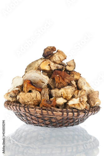 Heap of dry mushrooms in a wooden plate. Isolated