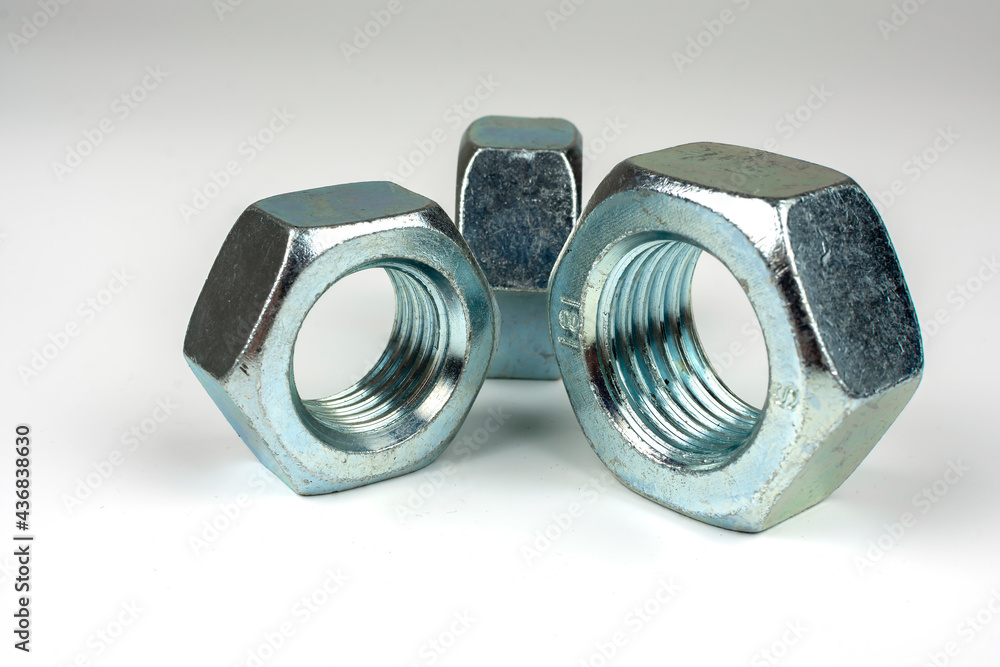 group of bolts and nuts made of light metal on a white background group of bolts and nuts made of light metal on a white background