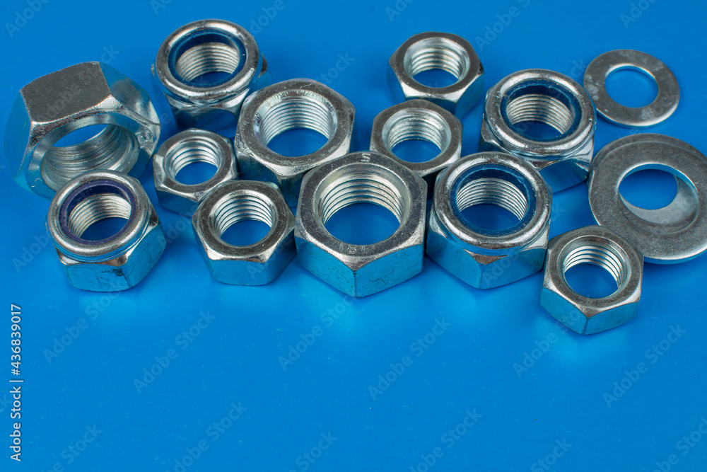 metal nuts and washers on blue background with copy space metal nuts and washers on blue background with copy space