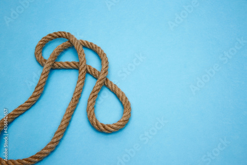 Sea shells, wooden boat and rope on a blue background.