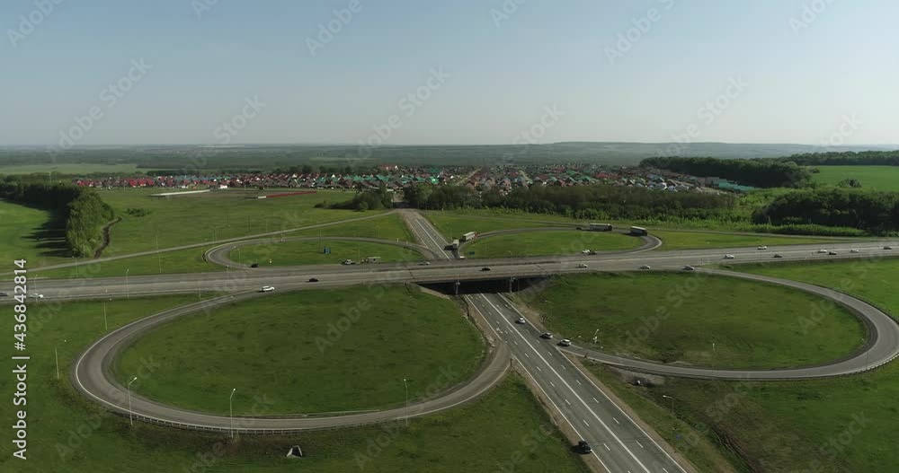 Semi Truck with white trailer and cab driving, traveling on road junction with overpass road, highway intersection aerial view. Freeway trucks traffic Semi Truck with white trailer and cab driving, traveling on road junction with overpass road, highway intersection aerial view. Freeway trucks traffic