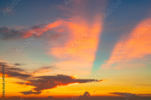 Beautiful sunset sky. Orange and blue sunset sky with beautiful pattern of clouds. Orange, red, and blue clouds at dusk. Freedom and calm background. Beauty in nature. Powerful and spiritual scene.