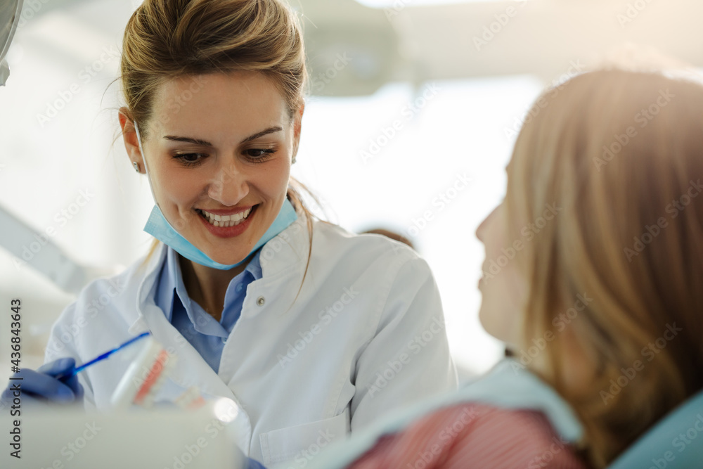 Female beautiful dentist is showing to patient how to brush teeth properly. Female beautiful dentist is showing to patient how to brush teeth properly.
