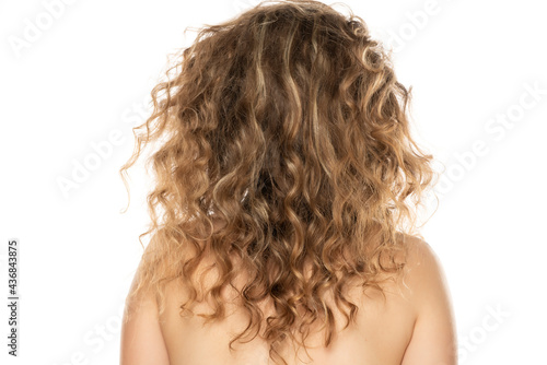 Rear view of of a blonde woman with curly long hair