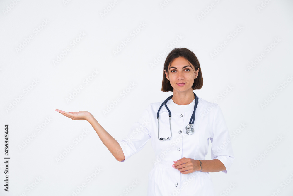 Female doctor in lab coat on white background isolated, confident smile hold hand left with empty space Female doctor in lab coat on white background isolated, confident smile hold hand left with empty space