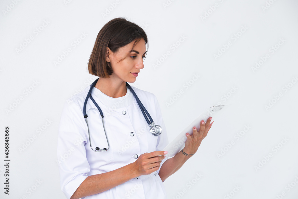 Female doctor in lab coat on white background isolated, confident smile hold white paper blank