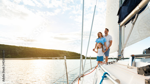 Joyful Family Standing On Sailboat Deck Enjoying Yacht Ride