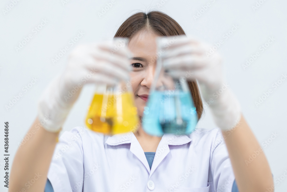 A young woman researcher, doctor, scientist, or laboratory assistant working with plastic medical tubes to research, examine scientific experiments in a modern laboratory. Education stock photo A young woman researcher, doctor, scientist, or laboratory assistant working with plastic medical tubes to research, examine scientific experiments in a modern laboratory. Education stock photo