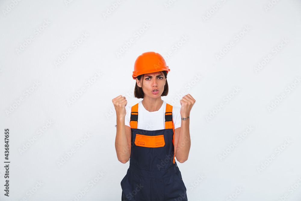 Pretty woman engineer in building protective helmet on white background angry swears at workers Pretty woman engineer in building protective helmet on white background angry swears at workers