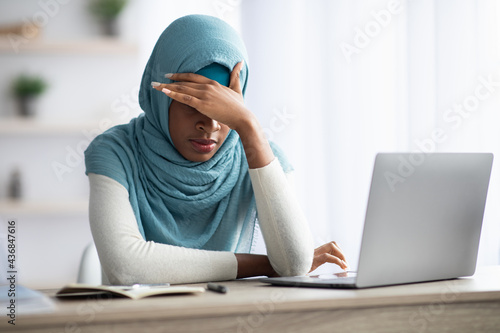 Deadline Stress. Black Muslim Lady Tired After Working With Laptop At Home
