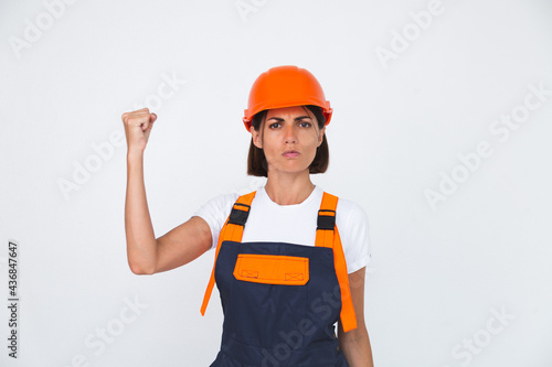 Pretty woman engineer in building protective helmet on white background angry swears at workers
