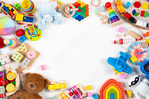 Baby kids toys frame. Set of colorful educational wooden, plastic and fluffy toys on white background. Top view, flat lay photo