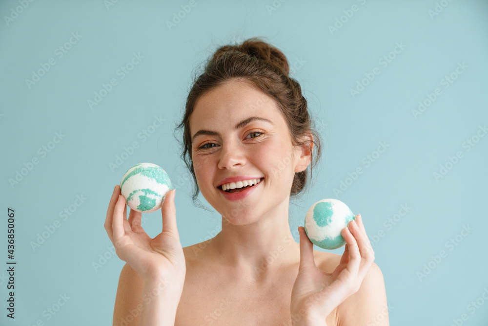 Half-naked brunette woman smiling while posing bath bombs Half-naked brunette woman smiling while posing bath bombs