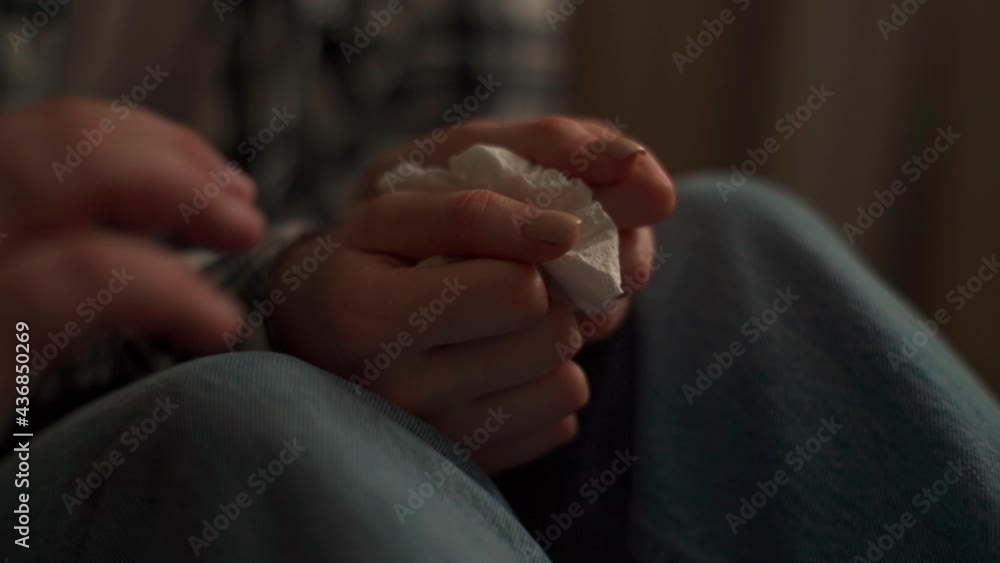 Close-up hands of unrecognizable friendly hand sympathetically the crying arm of woman, holding paper tissues damp with tears. Psychologist touching depressed female for encouragement. Close-up hands of unrecognizable friendly hand sympathetically the crying arm of woman, holding paper tissues damp with tears. Psychologist touching depressed female for encouragement.