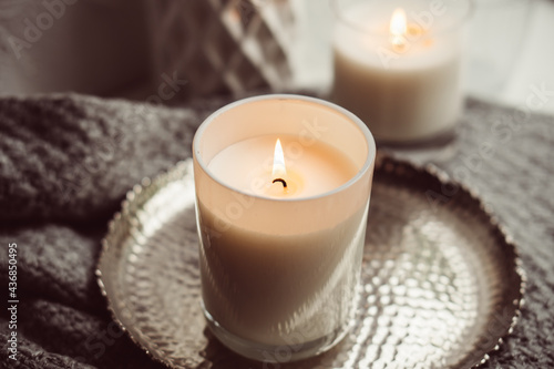 Картината върху платно White burning candle in glass candleholder on vintage metal tray, warm cozy home
