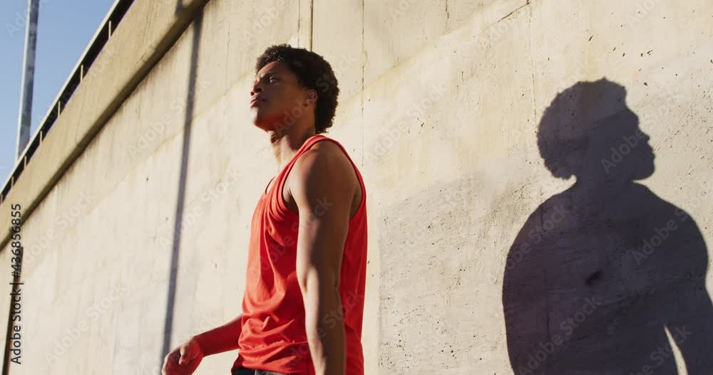 Fit african american man exercising outdoors in city, bouncing basketball Fit african american man exercising outdoors in city, bouncing basketball