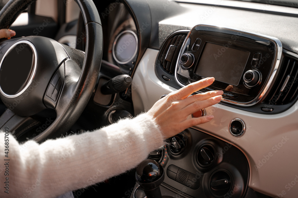 Woman hand pushing monitor screen in car
